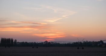 agricultural sprinkler standing in a field at dusk