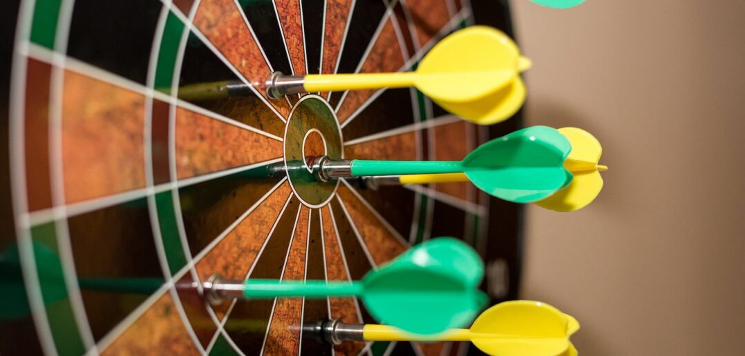 green and yellow darts on brown black green and red dartboard